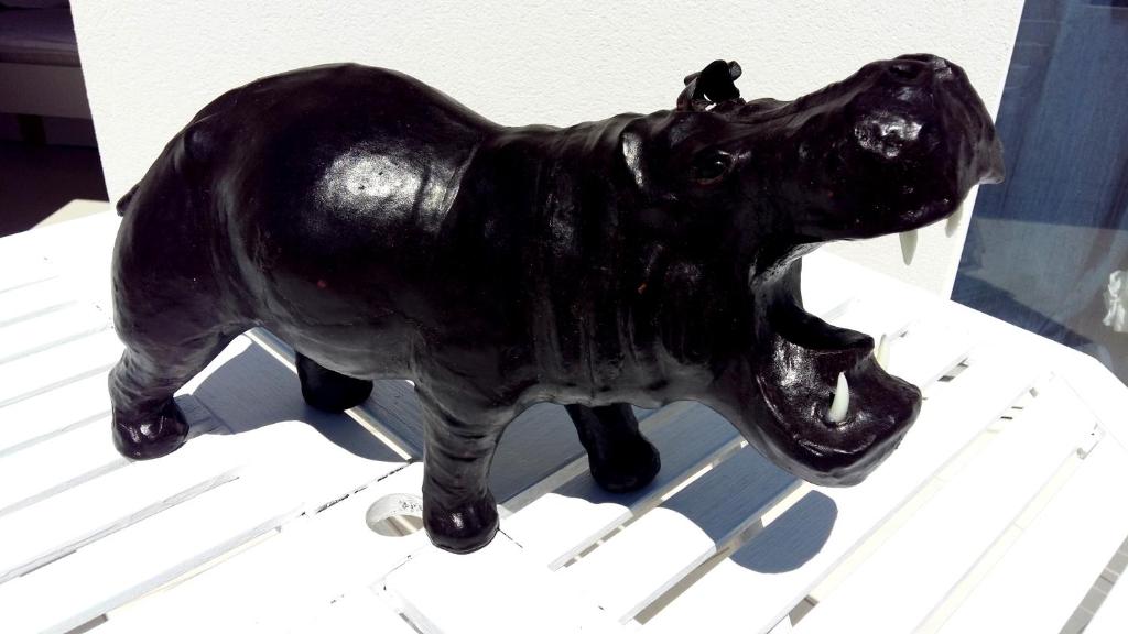 a statue of a black dog sitting on a chair at Apartments House of Art in Nin