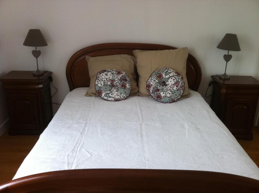 1 cama con 2 almohadas y 2 lámparas en Petite escale Vivonnoise, en Vivonne