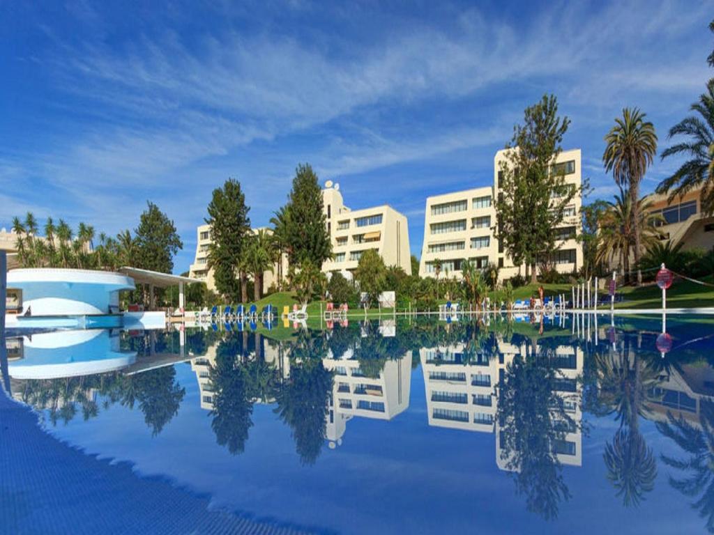 a view of a resort with a reflection in the water at Vila Marachique in Alvor