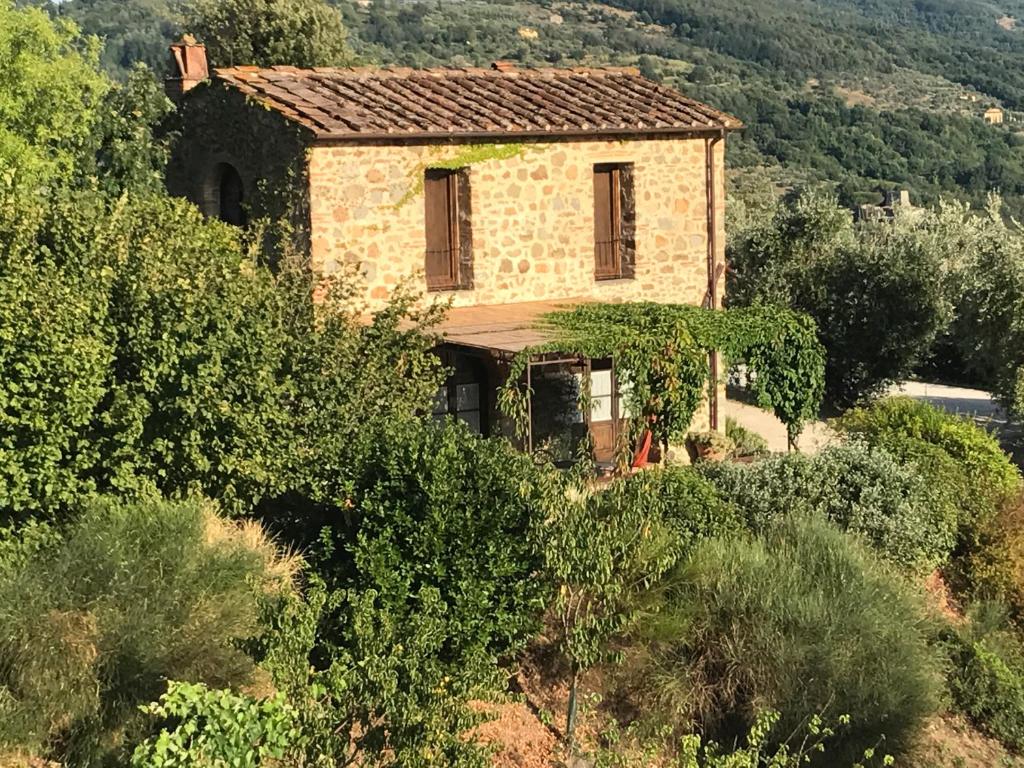 une ancienne maison en pierre sur une colline avec des arbres dans l'établissement Podere La Fausta, à Serravalle Pistoiese