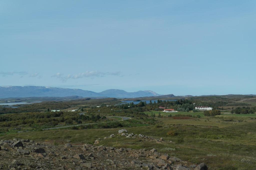 a view of a field with mountains in the distance at Eidavellir Apartments and Rooms in Egilsstadir