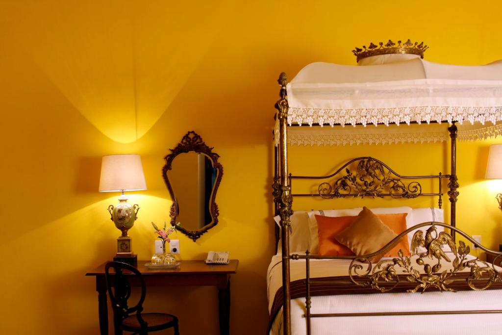 a bedroom with a bed and a mirror at Hotel Boutique Casa Don Gustavo, Campeche in Campeche