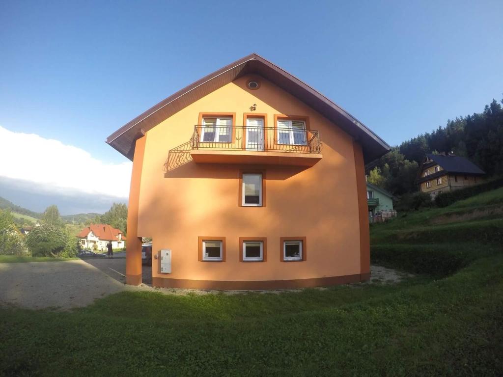 a house with a balcony on the side of it at Noclegi u Gosi in Ustrzyki Dolne