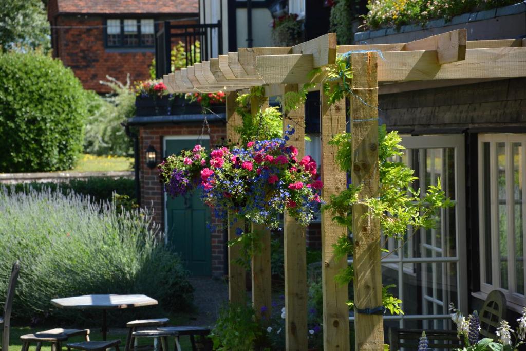 a garden with flowers hanging from a pergola at The Dolphin Inn in Thorpeness