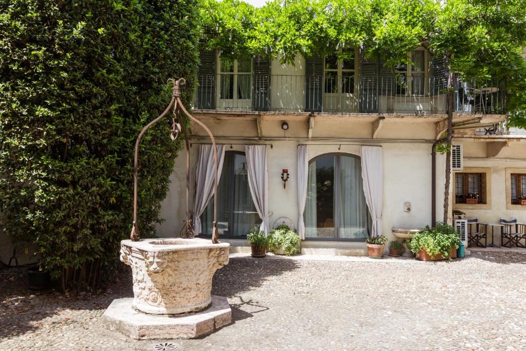 a house with a stone fountain in front of it at Palazzo Fracastoro in Verona