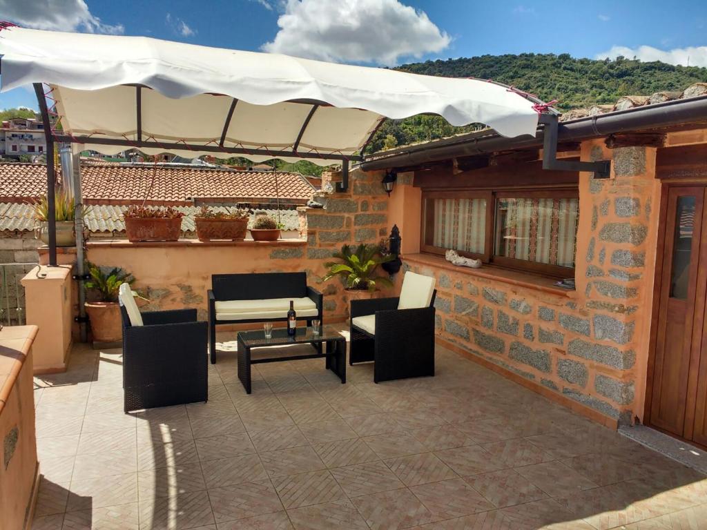 a patio with chairs and a table and an umbrella at La Palma in Bari Sardo