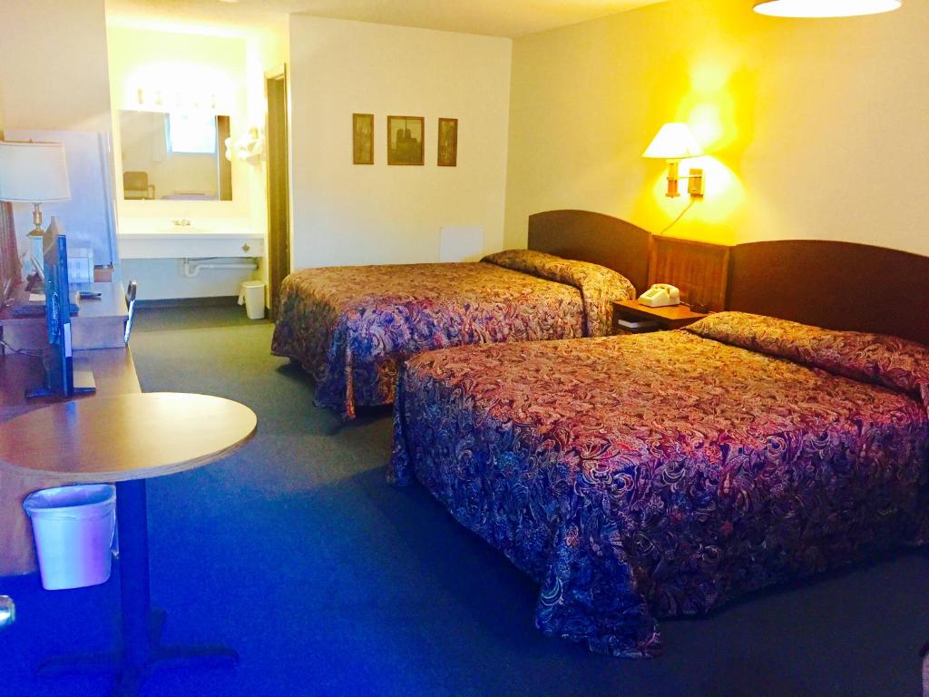 una habitación de hotel con dos camas y una mesa en Rock City Motel, en Minneapolis