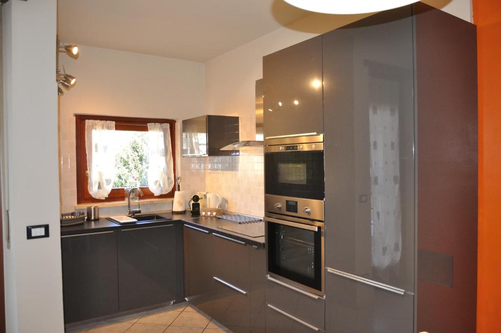 una cucina con elettrodomestici in acciaio inossidabile e armadi marroni di Appartamento Nino ad Aosta