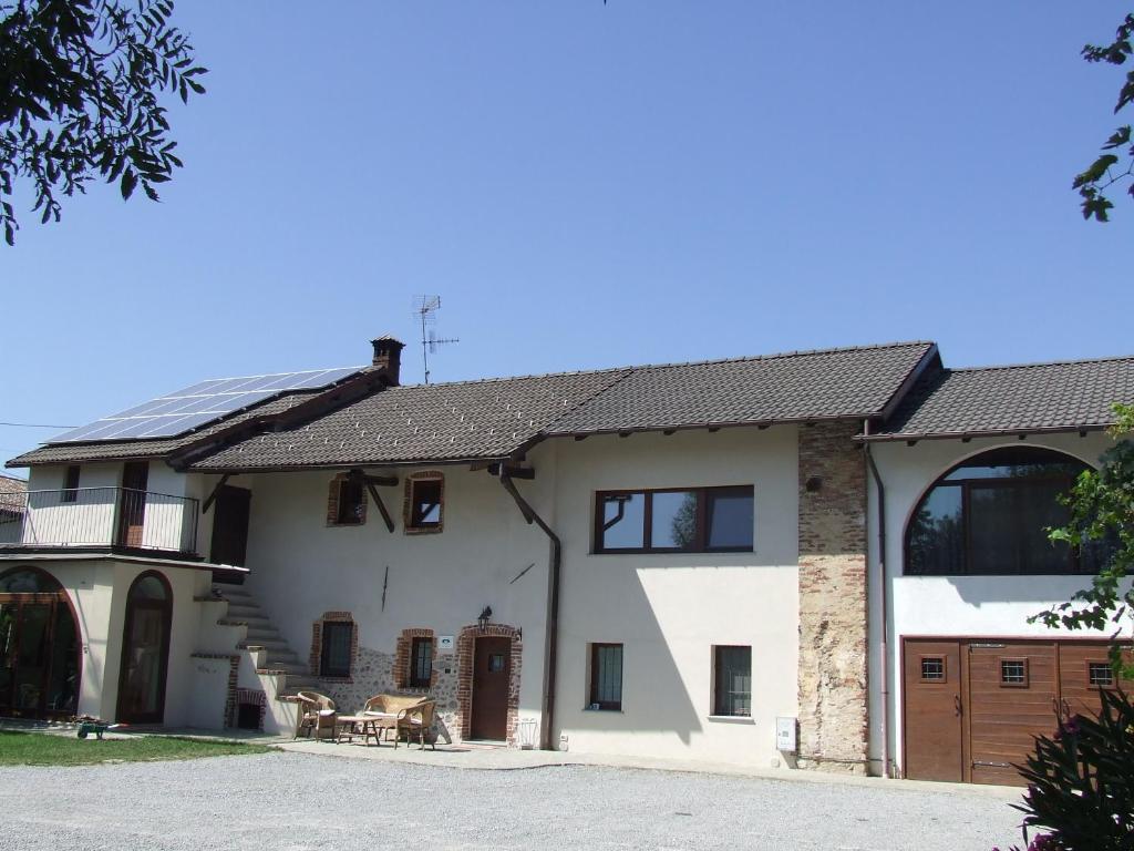 a large white house with a garage at La Meridiana, monolocale in cascina ristrutturata in Boves