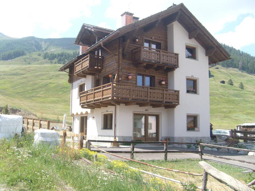 a house with a balcony on top of a hill at Baita Fetaplana in Livigno