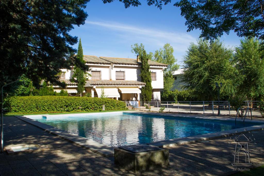 a swimming pool in front of a house at Finca El Molino in Ajofrín