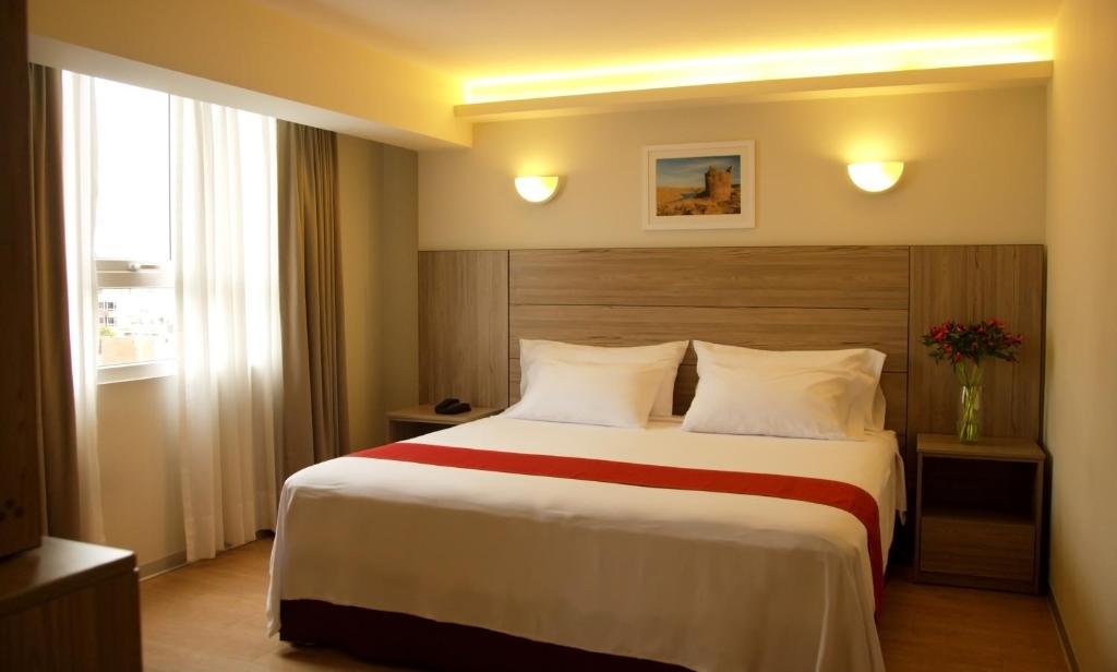 Habitación de hotel con cama grande y ventana en Hotel San Remo, en Lima