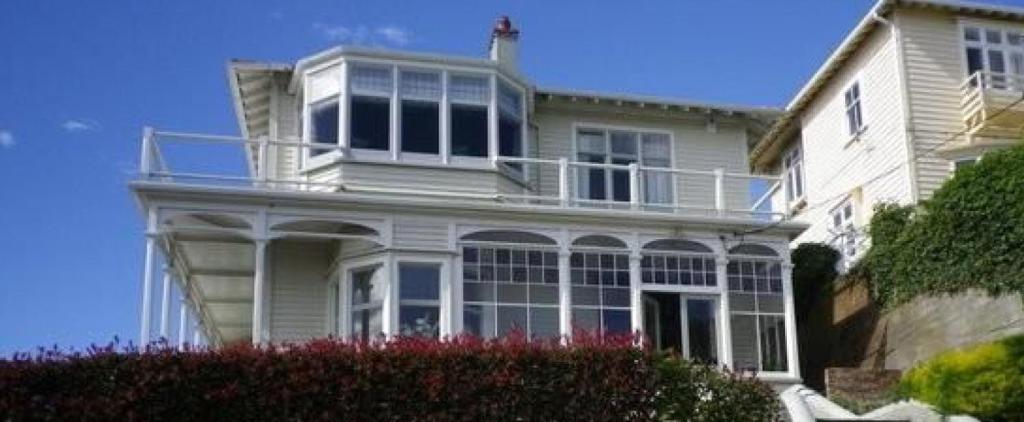 a large white house with a balcony on top of it at BnB at Bidwill in Wellington