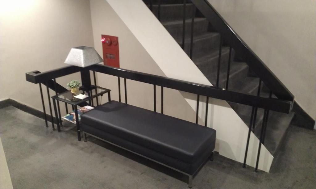 a person sitting on a bench next to a staircase at Royal Hotel in Taipei