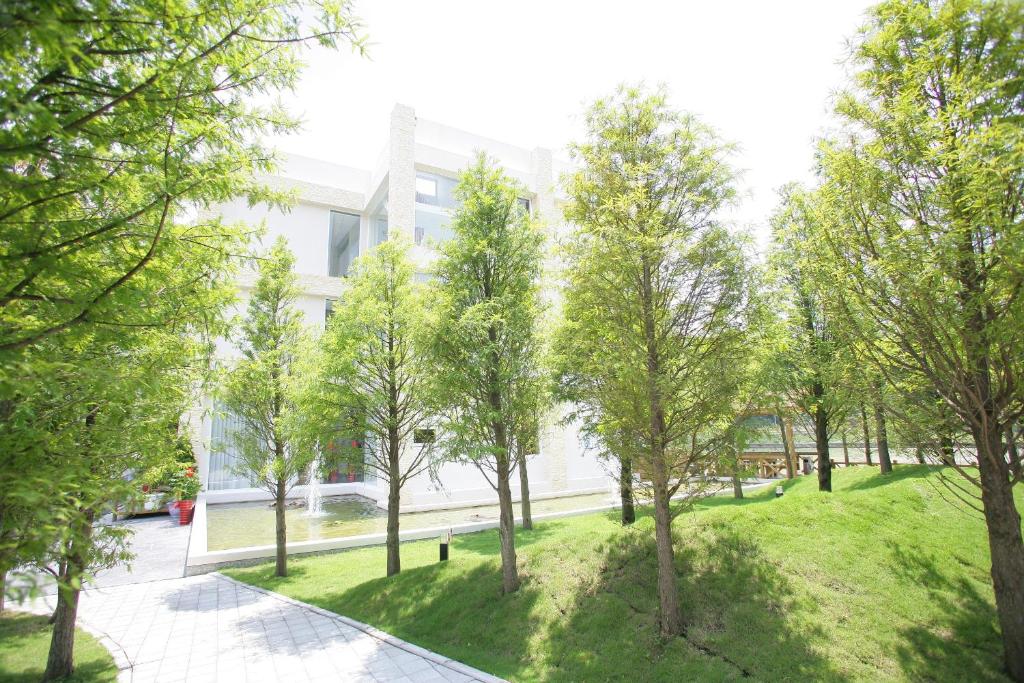 - une vue sur un parc avec des arbres devant un bâtiment dans l'établissement Xianel Vacation Chateau, à Dahu