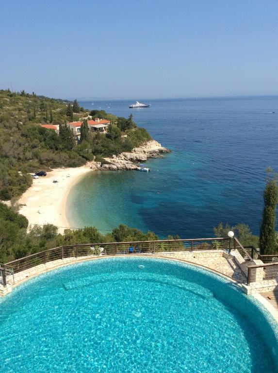 a large swimming pool next to a beach at Paxos villas in Gaios