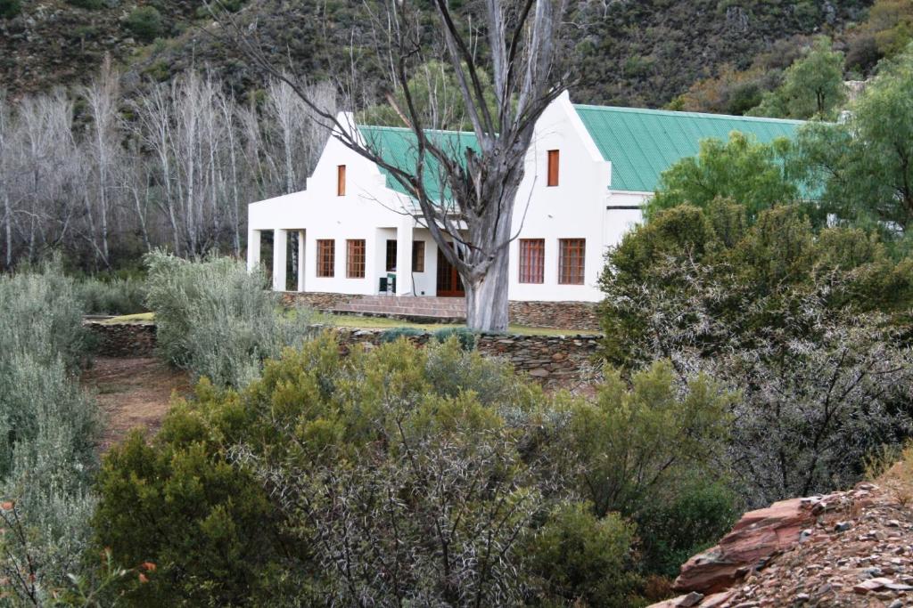 a white house with a green roof at Matjiesvlei Retreat Swartskaap/Blacksheep in Calitzdorp