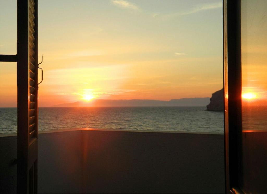 einen Sonnenuntergang von einem Kreuzfahrtschifffenster aus gesehen in der Unterkunft Armyra Hotel in Skala