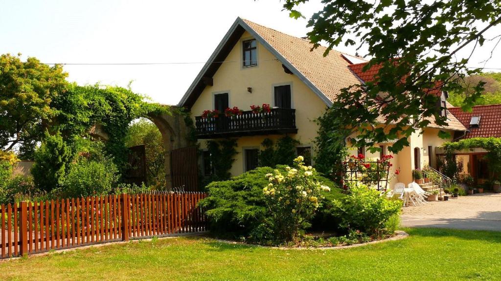 een huis met een hek en bloemen in de tuin bij Ferienwohnungen Lindleshof in Leinach