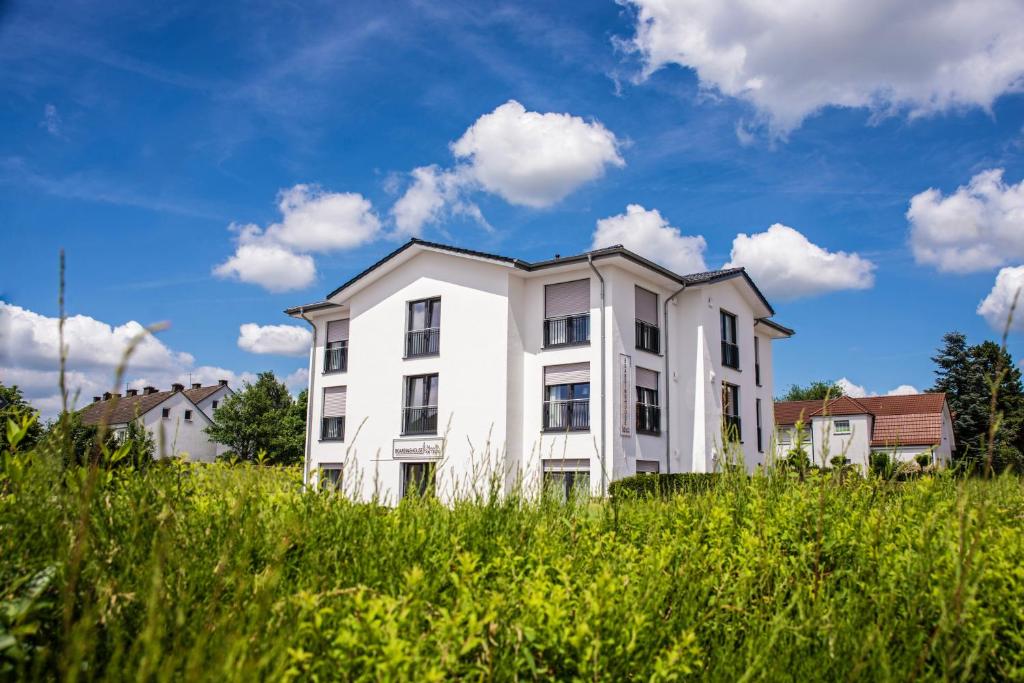 una casa bianca in un campo di erba alta di Boardinghouse am Teuto a Lengerich