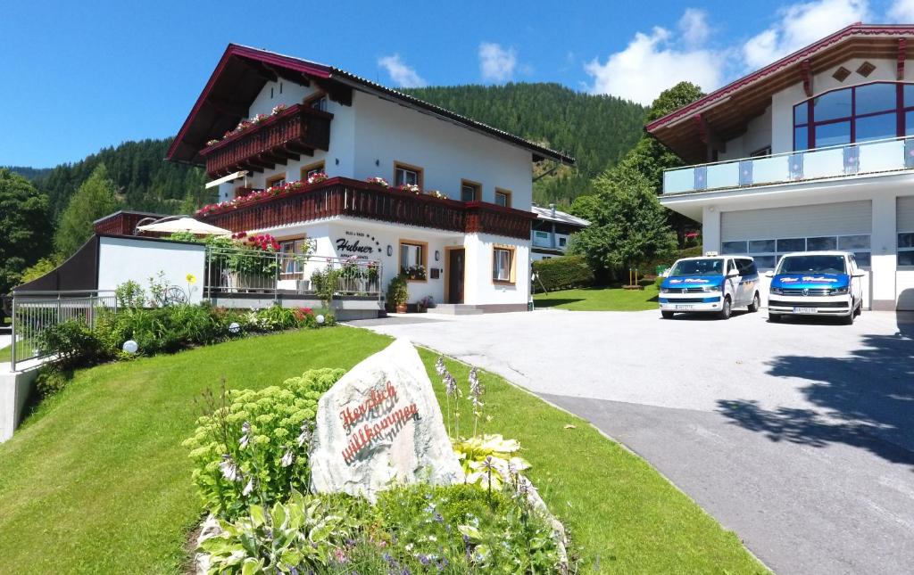 dom z dwoma samochodami zaparkowanymi przed nim w obiekcie Appartement Hubner w mieście Ramsau am Dachstein