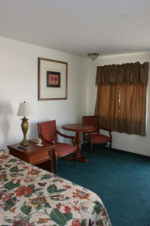 a hotel room with a bed and a table and chairs at HWY Express Inn and Suites in Thatcher