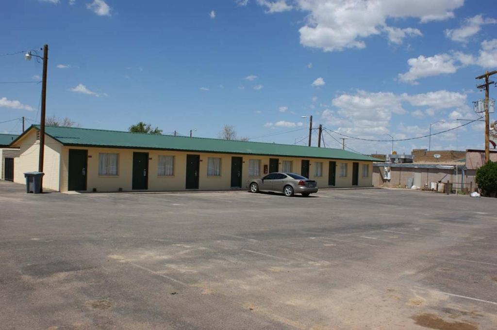 a building with a car parked in a parking lot at HWY Express Inn and Suites in Thatcher
