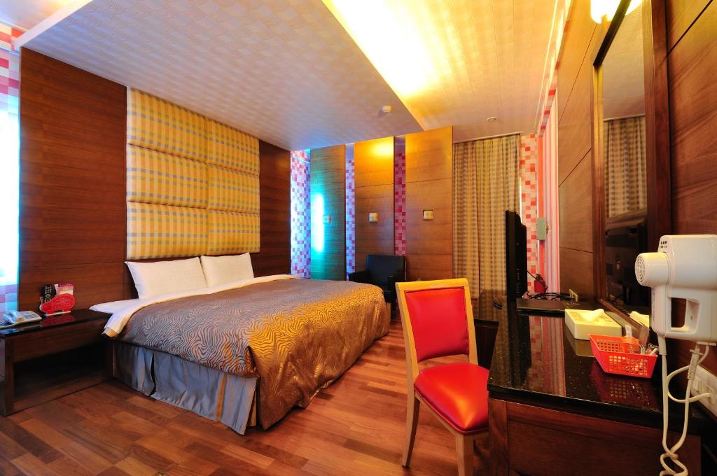 una camera con letto, scrivania e sedia di Hua Xiang Motel - Da Liao a Daliao