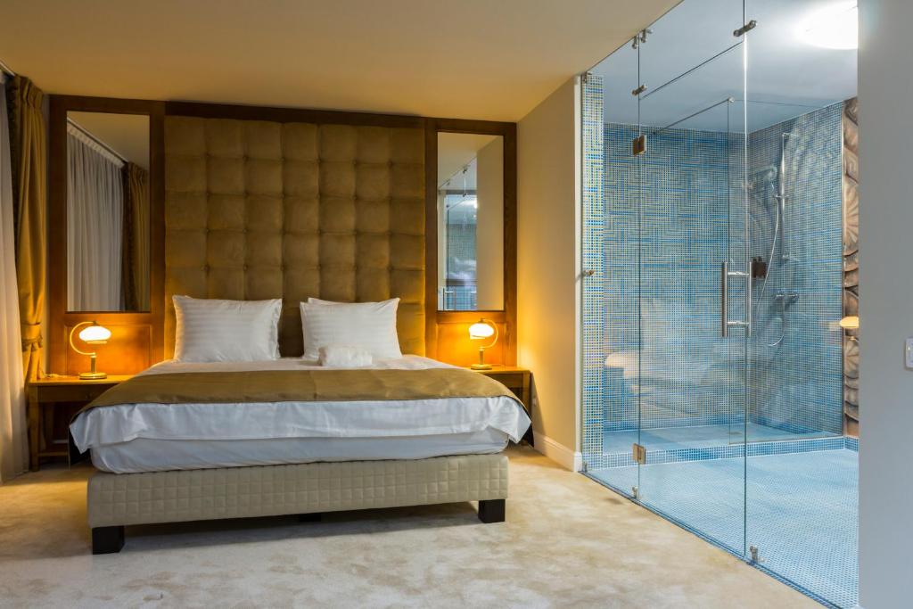 ブカレストにあるGanzo Boutique Hotelのベッドルーム1室(ベッド1台、ガラス張りのシャワー付)