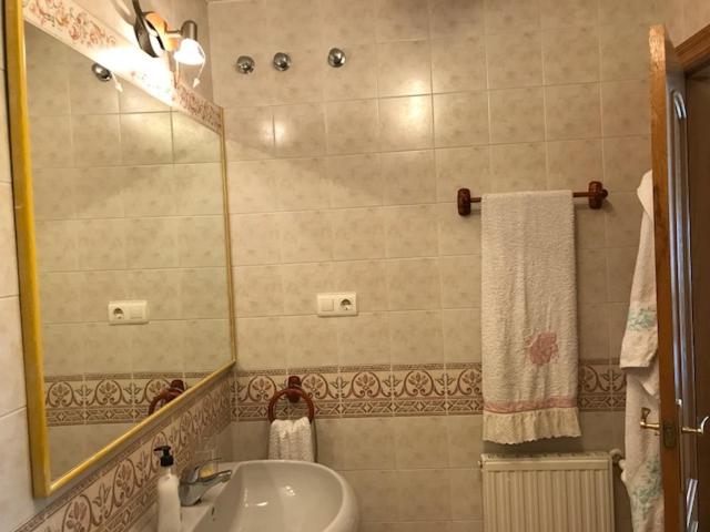 y baño con lavabo y espejo. en Apartamentos Las Fuentes, en Castropol