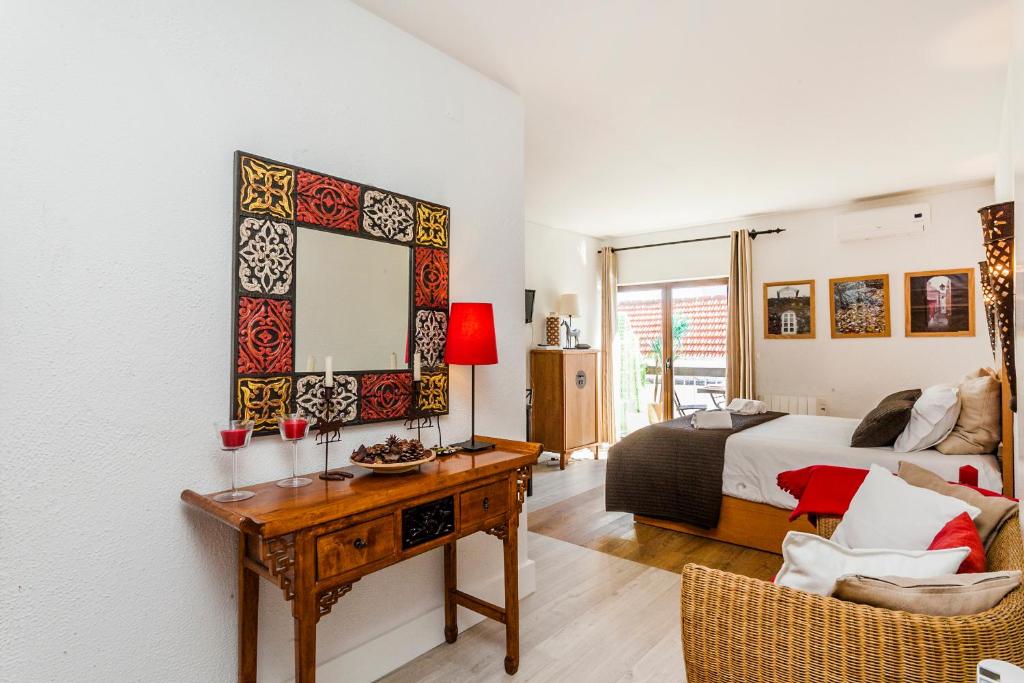 a bedroom with a bed and a desk with a mirror at Gomes Freire Studio with Balcony in Cascais