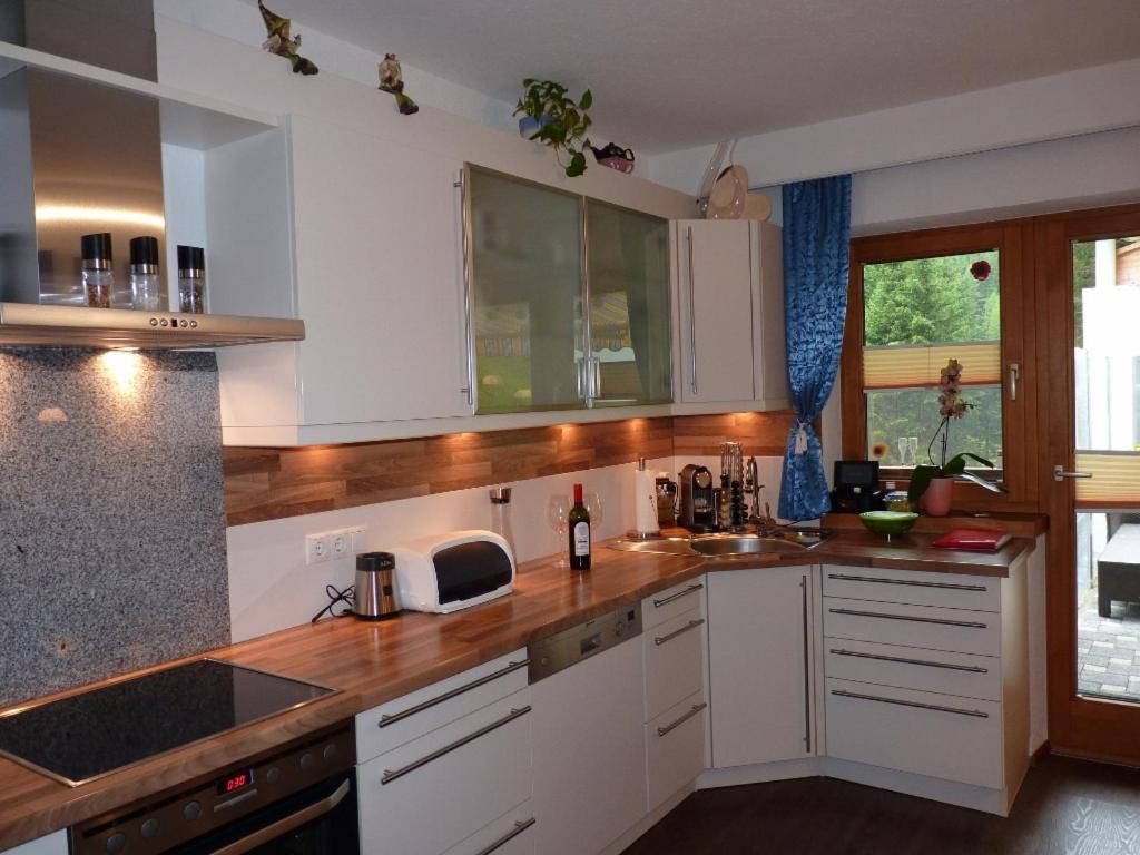 a kitchen with white cabinets and wooden counter tops at Alpenspirit in Sölden