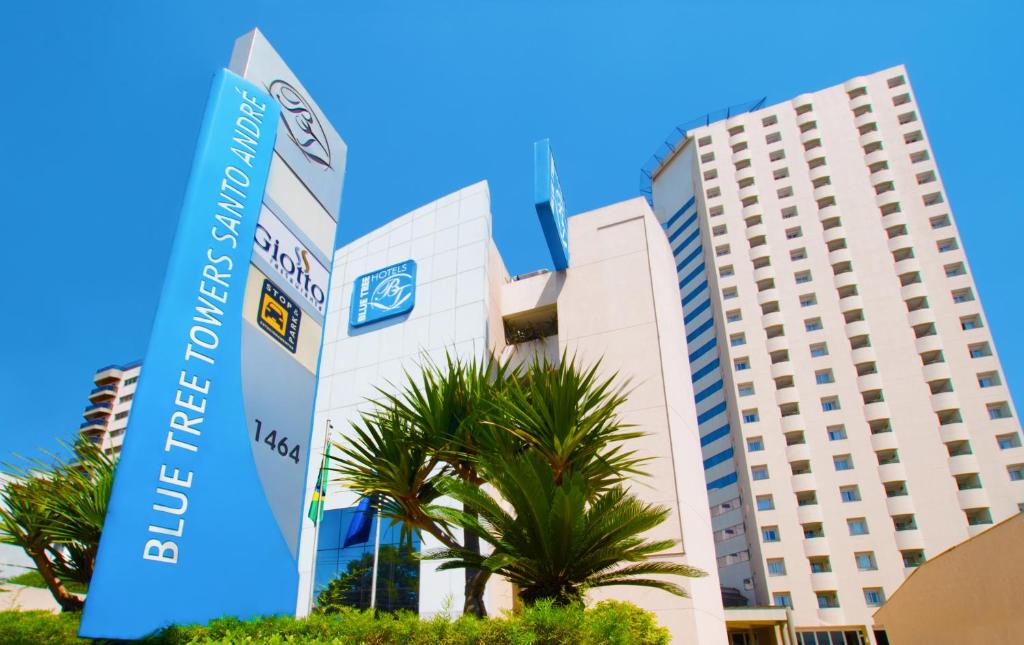 a building with a palm tree in front of it at Blue Tree Towers All Suites Santo André in Santo André