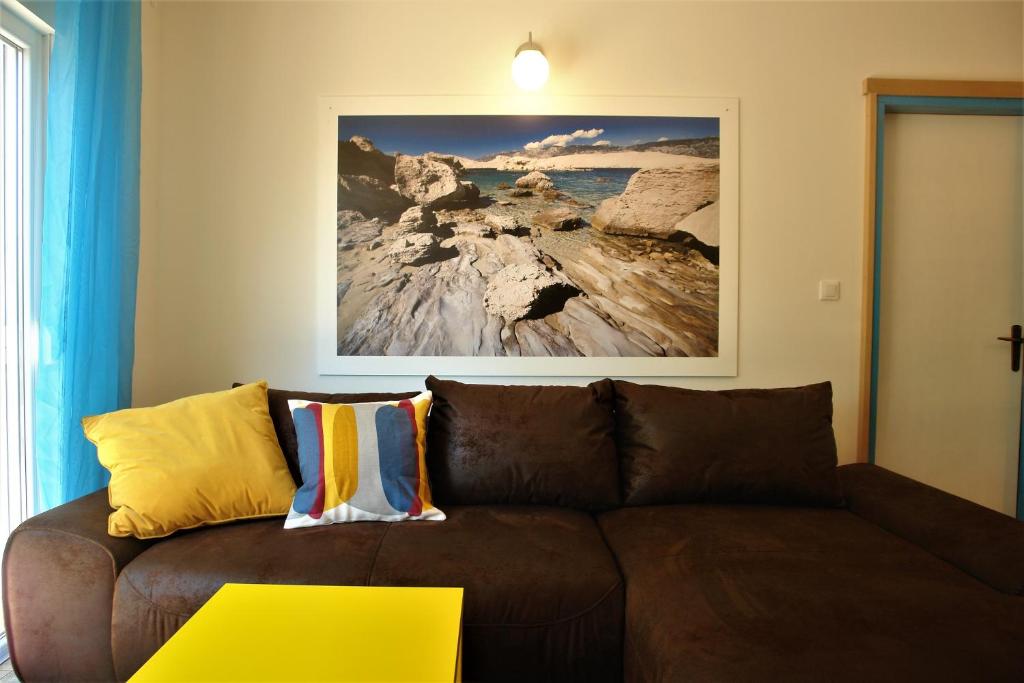 a brown couch in a living room with a picture on the wall at Quercus Apartment in Stara Baška