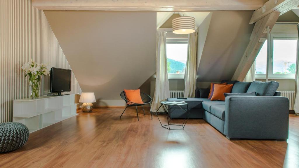sala de estar con sofá azul y TV en Hotel & Restaurant Sonne, en Kirchzarten