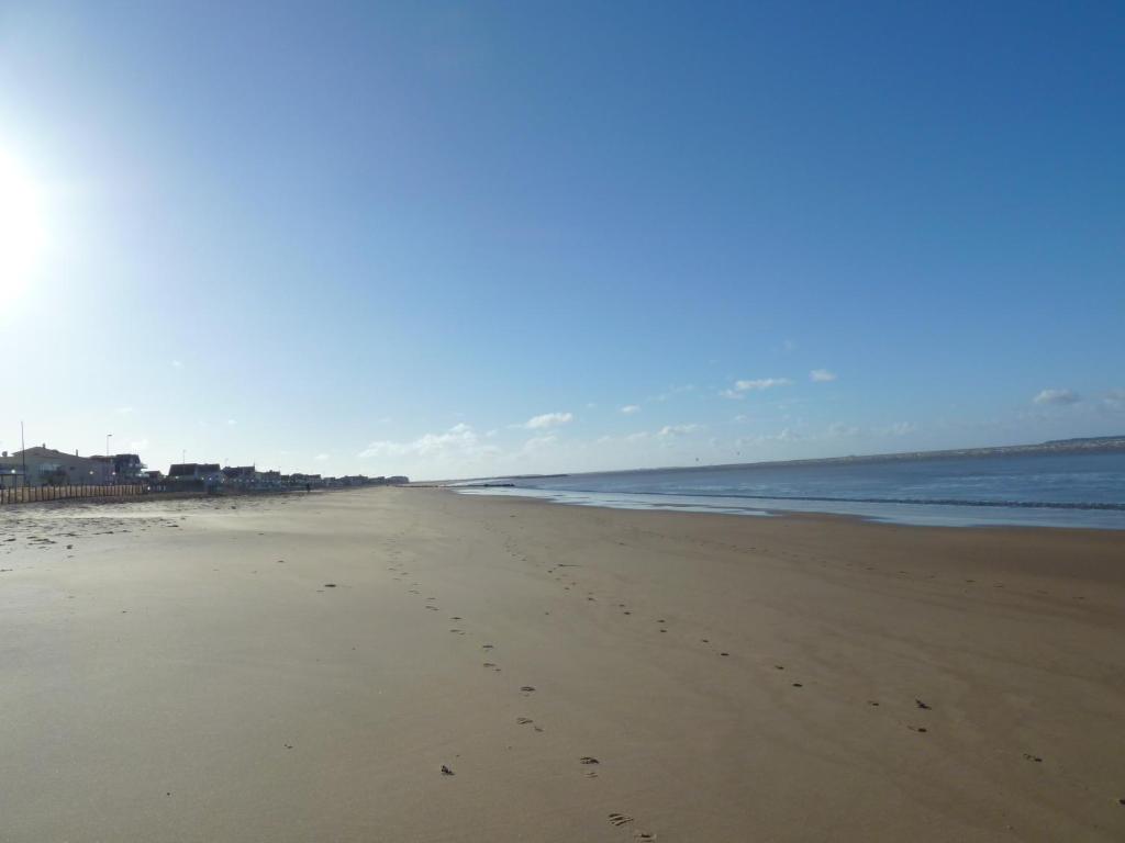 een strand met voetafdrukken in het zand en de oceaan bij Guzzo in Châtelaillon-Plage