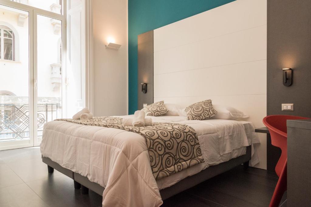 une chambre avec un grand lit dans une pièce dans l'établissement FALERON Santa Lucia, à Naples
