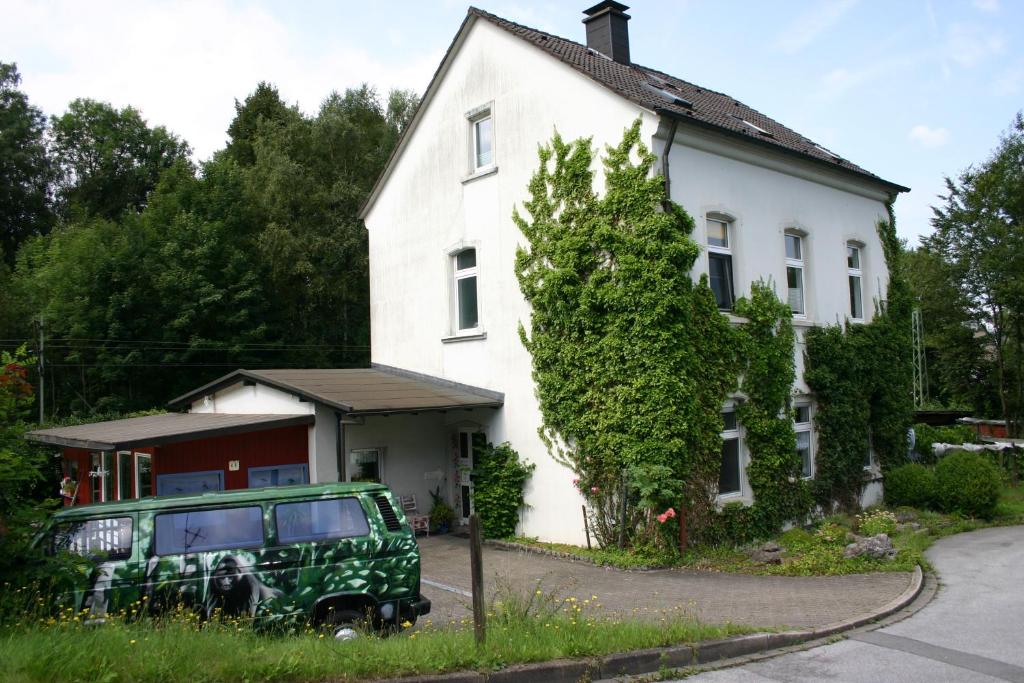 ein grüner Jeep, der vor einem weißen Haus parkt in der Unterkunft Alter Bahnhof in Ennepetal