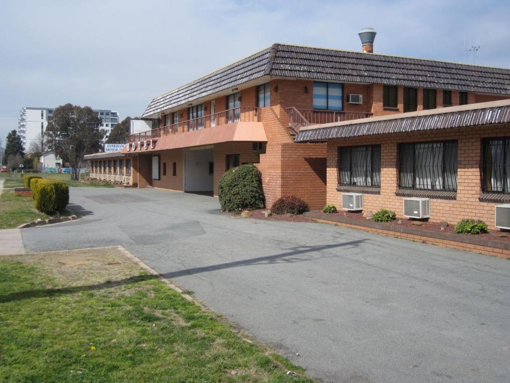 een bakstenen gebouw met een oprit ervoor bij Canberra Lyneham Motor Inn in Canberra