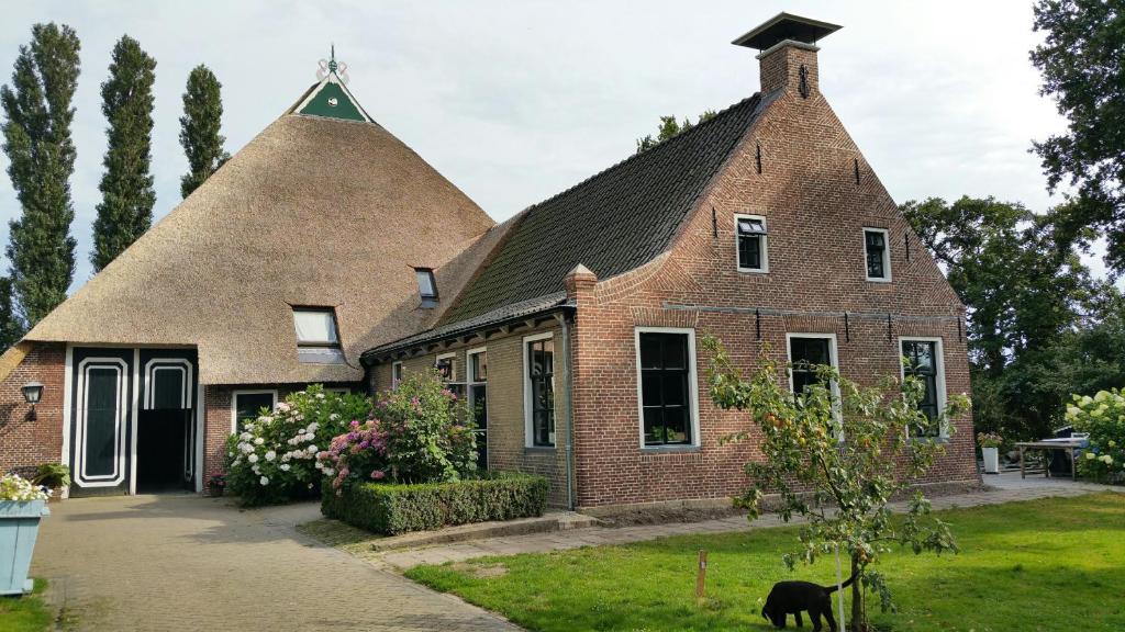 a large brick house with a thatched roof at Lyklamastate in Nijemirdum