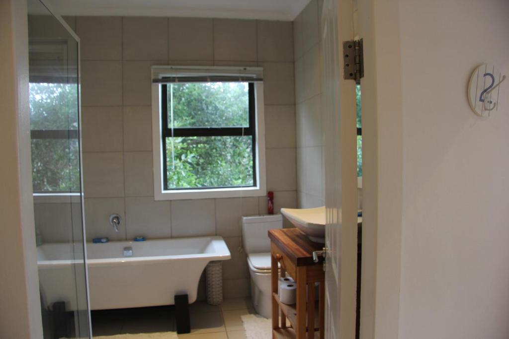 a bathroom with a tub and a toilet and a sink at Campismo Ninho 40 in Ponta Malangane