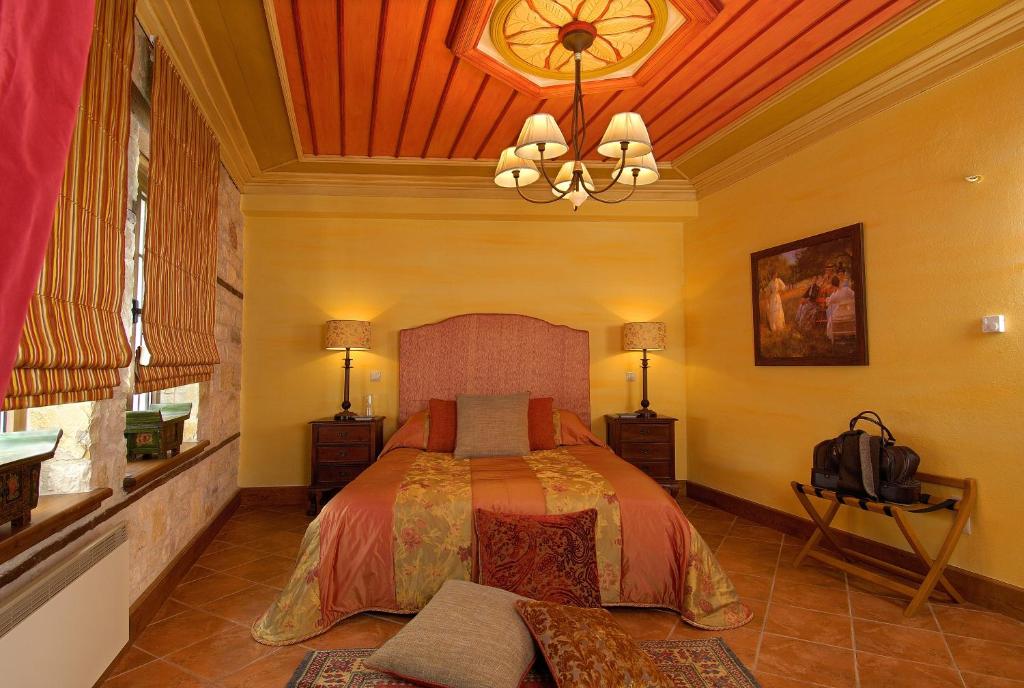 - une chambre avec un lit et un lustre dans l'établissement Emotions Country Resort, à Voútiron