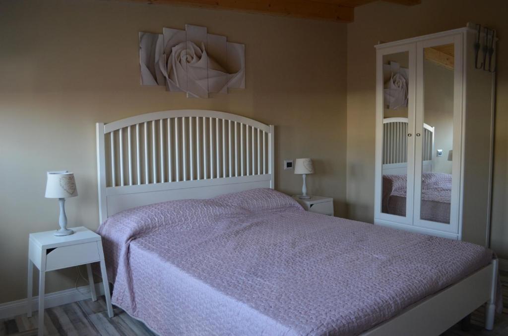 パルミにあるB&B Domus Palmiのベッドルーム1室(白いベッド1台、ナイトスタンド2台付)