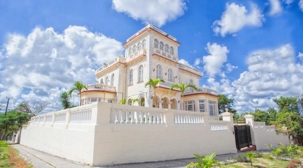a large house with a white fence in front of it at La Villa Teresa in Havana