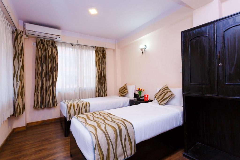 a hotel room with two beds and a window at Kathmandu City Hotel in Kathmandu