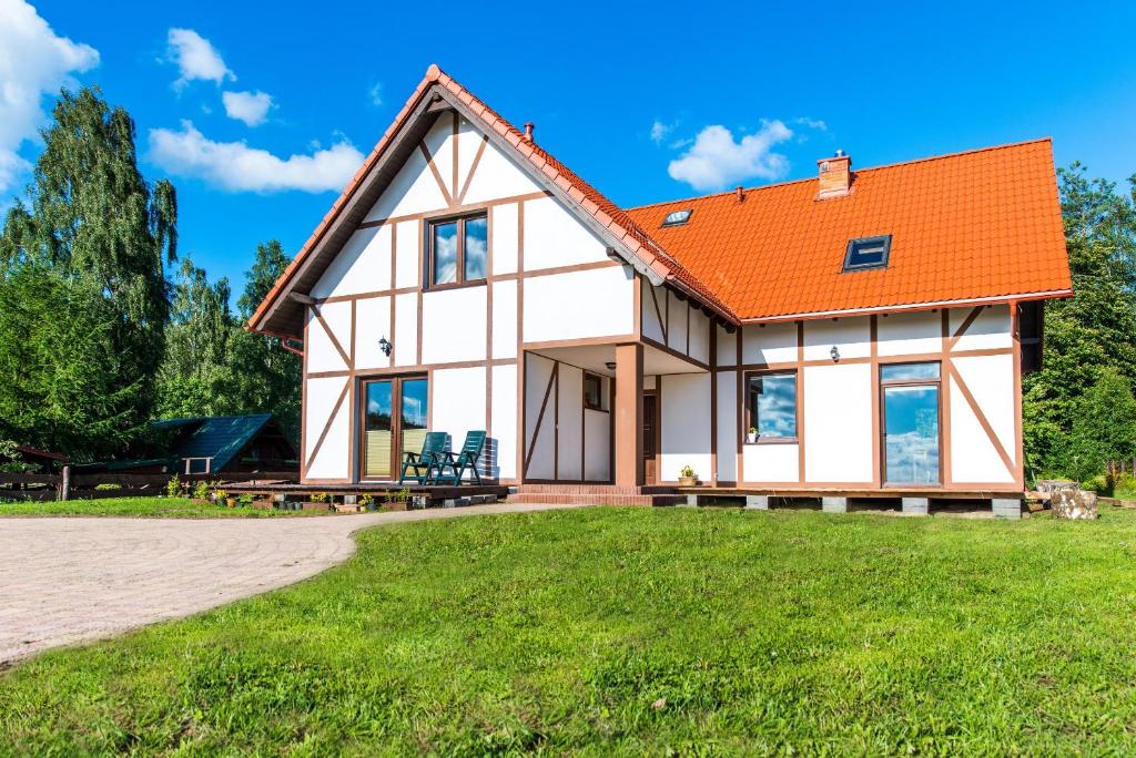 une maison avec un toit orange dans l'établissement Apartamenty Kaszuby, à Szymbark