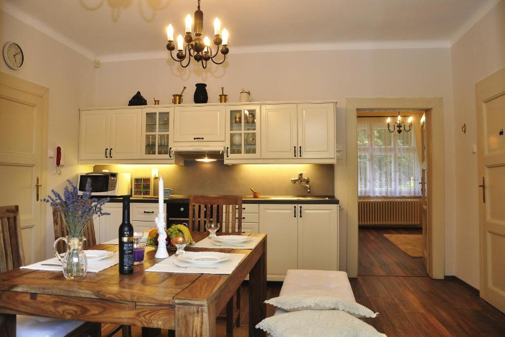 uma cozinha com uma mesa de madeira e armários brancos em Atmospheric Quiet Apartment em Praga