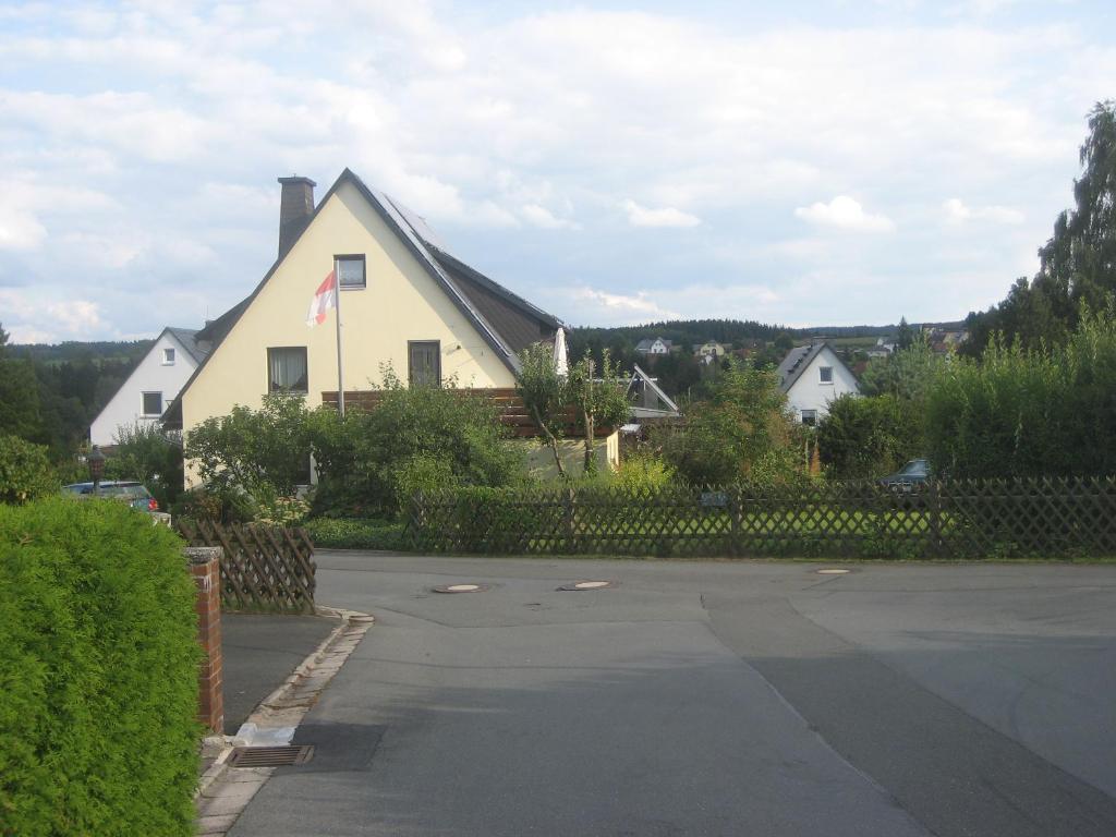 a house with a flag on the side of a street at Ferienwohnung Wölfel in Schwarzenbach an der Saale