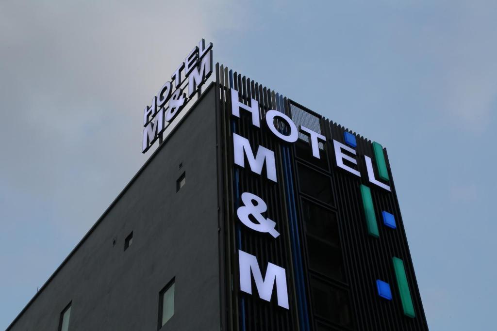 un edificio con il cartello dell'ospedale e dei manuali di M&M Hotel a Kuala Lumpur