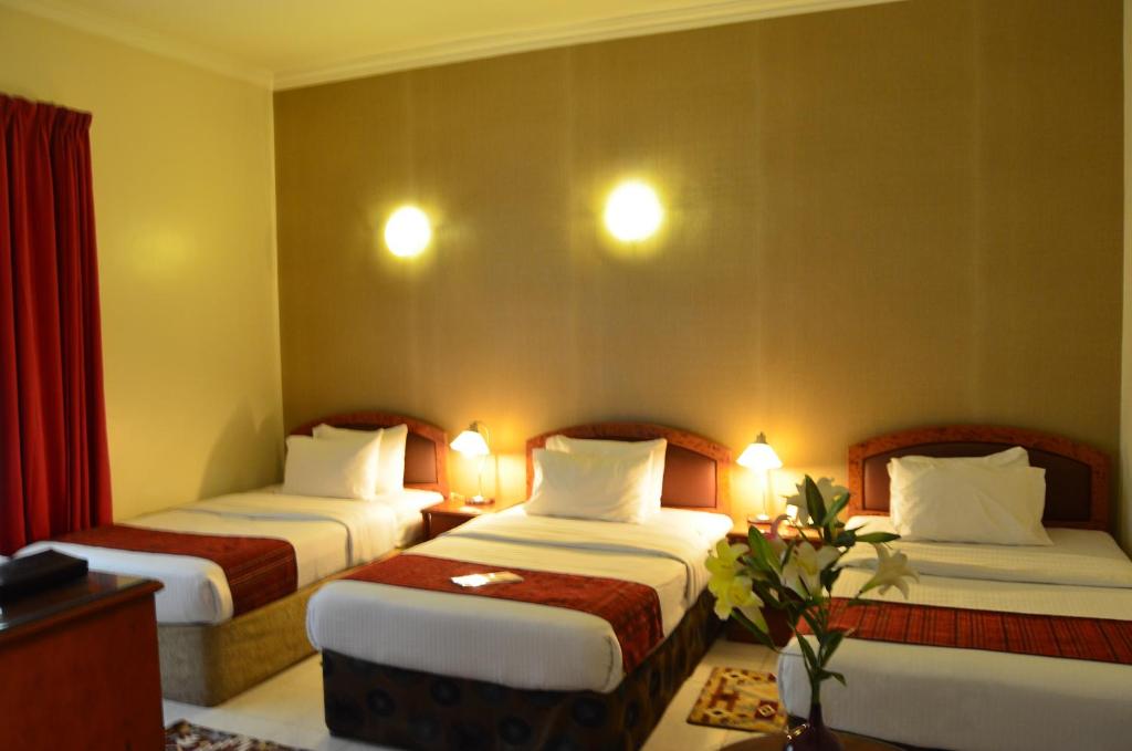 a hotel room with two beds with lights on them at Nejoum Al Emarat in Sharjah